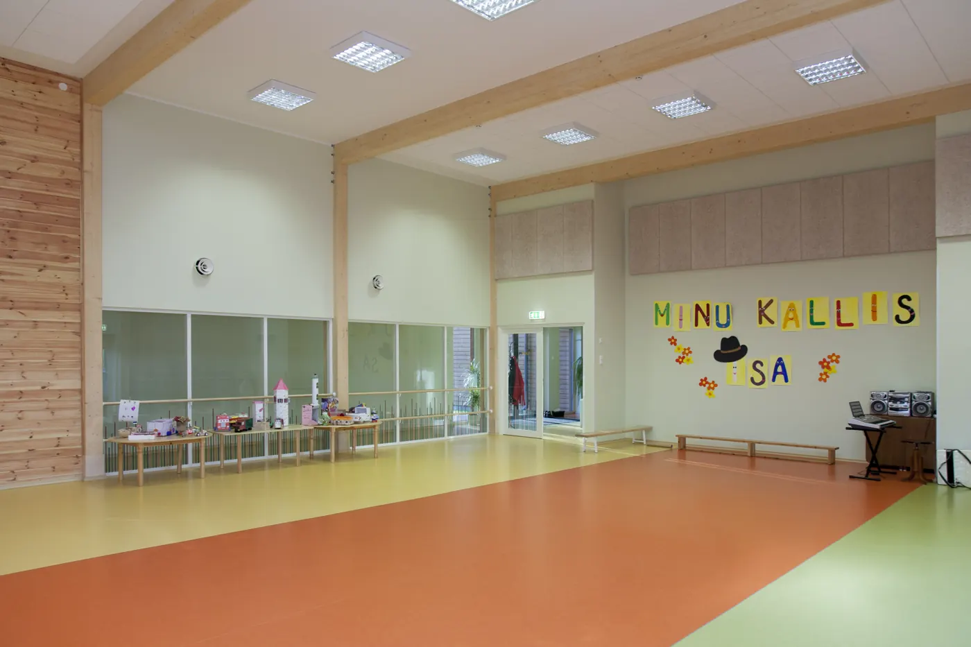 Salón múltiple de colegio con piso vinílico en rollo homogéneo en tres colores